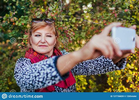Middle Aged Woman Taking Selfie On Phone Senior Lady Having Fun In