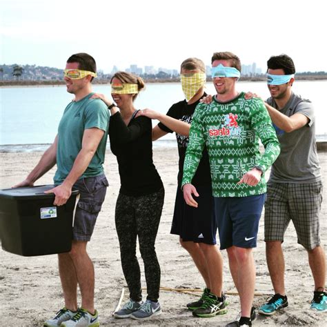 Blindfolded Challenge Players Are Guided By A Caller Through A Course To Pick Up Tubs