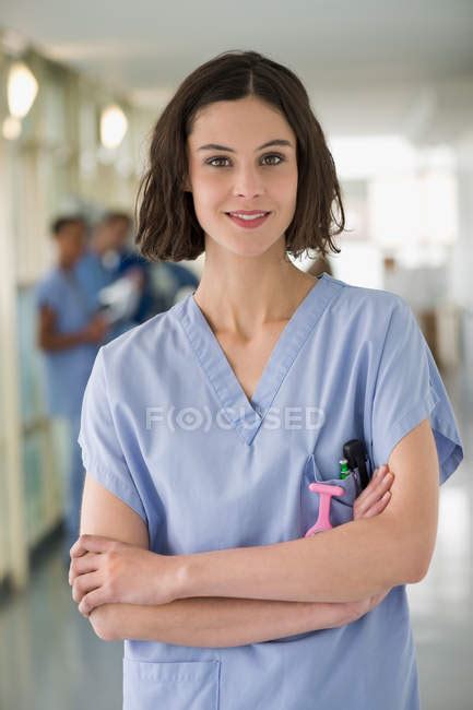 Portrait Of Smiling Female Nurse Standing With Arms Crossed — Caucasian