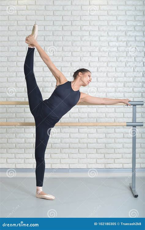 Ballerina Stretches Herself Near Barre At Ballet Studio Full Length