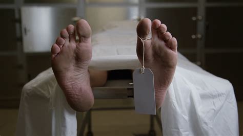 morgue tilt   feet  gurney  sheet male body corpse stock