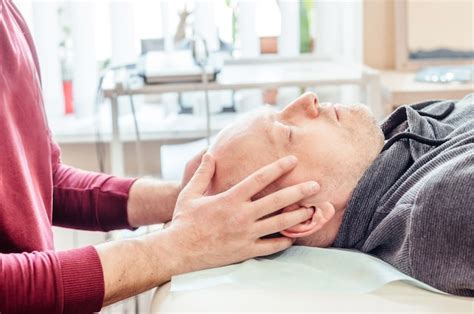 premium photo male patient receiving cranial sacral therapy lying on the massage table in cst