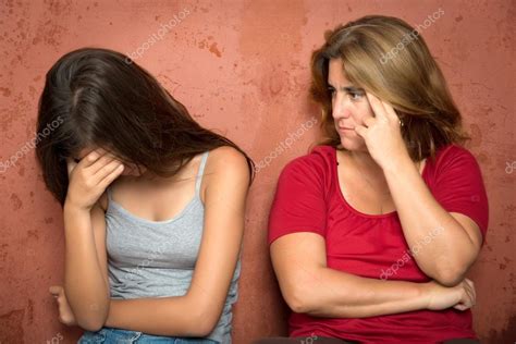 Грустная плачущая девочка подросток и ее обеспокоенная мать стоковое фото kmiragaya
