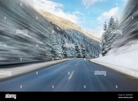 Winter Alpine Road Curve Landscape With Forest Mountains And Blue Sky