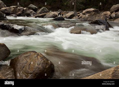 Silky Slow Motion River Water Flowing Over And Around Large Boulders In