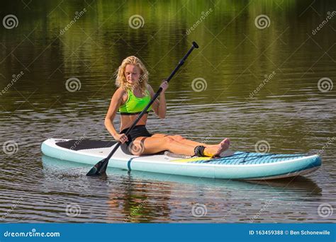 Sitting Young Woman Paddling With Sup On Water Stock Photo Image Of