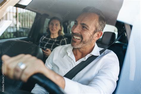 Foto De Taxi Driver Talking To A Female Passenger In Car Do Stock Adobe Stock