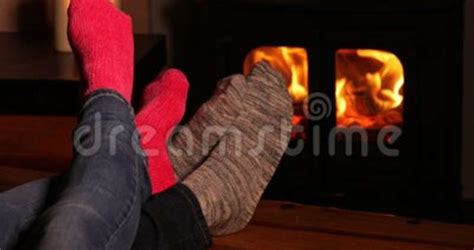 Close Up Of Cosy Couple At Home Wearing Socks Warming Feet Stock
