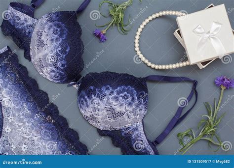 beautiful blue lace bra and panties with t box and beads on gray background women underwear
