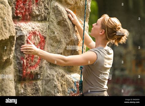 Female Rock Climber Attempts To Make Her Way Up An Old Stone Structure