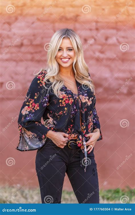 A Lovely Blonde Model Enjoys An Autumn Day Outdoors In A Small Town