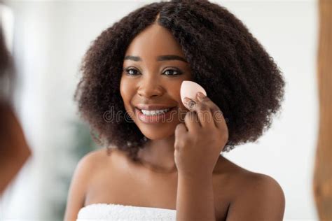 Lovely Young Black Woman With Soft Skin Applying Cosmetic Foundation
