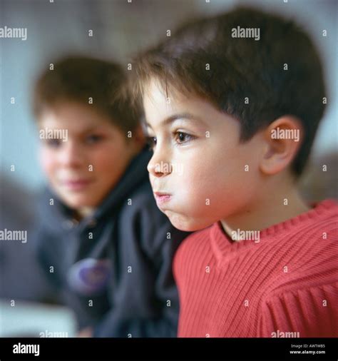 Boy Puffing Cheeks Out Second Boy Looking At Him In Background Stock