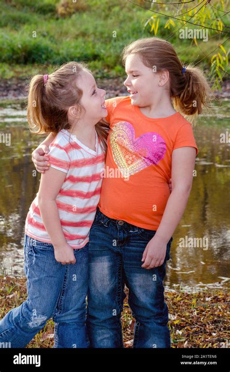 Two Little Girls Are Sisters And Best Friends As They Pose For A Photo