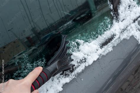 Scraping The Car Window With A Scraper From Ice And Snow The Concept