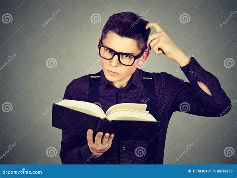 Confused Man In Glasses Perplexed After Reading A Book Stock Image