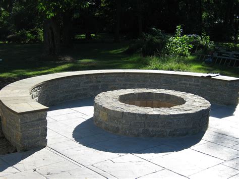 Retaining wall with natural stone fire pit. Fieldstone firepit, sitting wall with bluestone cap and st ...