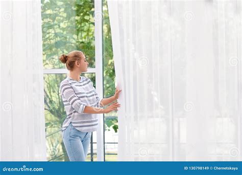 Young Woman Opening Curtains And Looking Out Stock Image Image Of