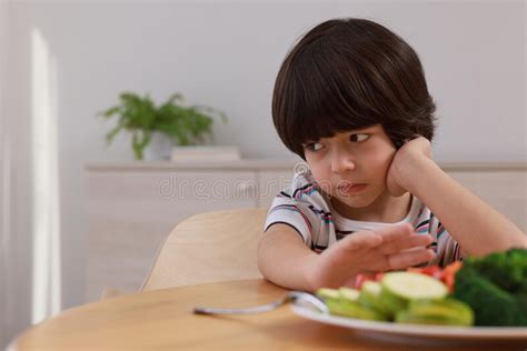 Cute Little Boy Refusing To Eat Vegetables At Home Space For Text