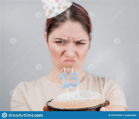 the unhappy woman is holding a cake with candles for her 25th birthday the girl is crying on