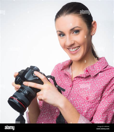 Smiling Female Photographer Holding A Digital Slr Camera And Posing On