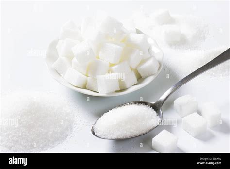 Spoonful Of Fine Granulated Sugar And Pile Of Sugar Cubes Stock Photo