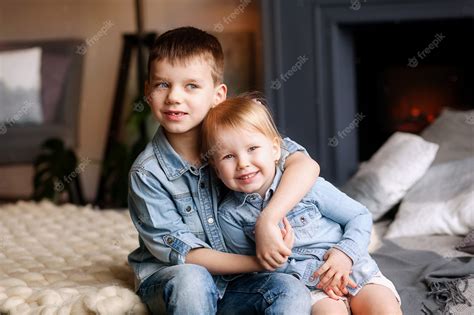 Niños Felices Hermano Y Hermana Se Sientan Y Abrazan Foto Premium