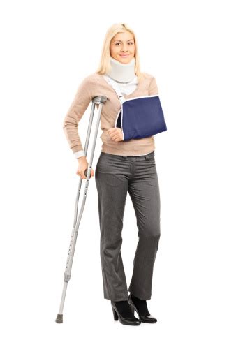 Happy Blond Female With Broken Arm Holding A Crutch Stock Photo