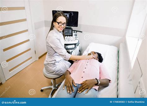 Young Smiling Woman Doctor In Diagnostic Center Making Ultrasound