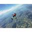 Female Skydiver Free Falling On Back Above Landscape  Stock Photo