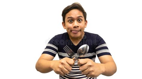 Funny And Hungry Face Expression Of Young Asian Malay Man With Strips T Shirt Holding A Spoon
