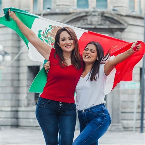 Two Young Women Possibly Mexican Holding Up A Mexican Flag In Mexico