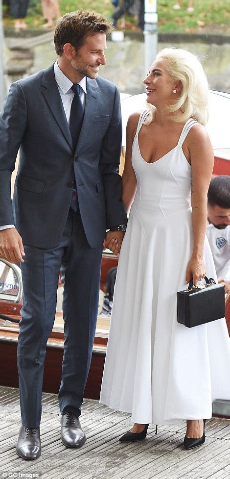 Ain't it hard keeping it so hardcore? Lady Gaga holds hands with Bradley Cooper at a photocall ...