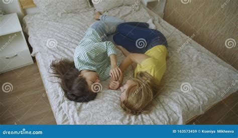 bovenste punt twee multinationale jonge vrouwen lesbiennes liggen in de slaapkamer op het bed