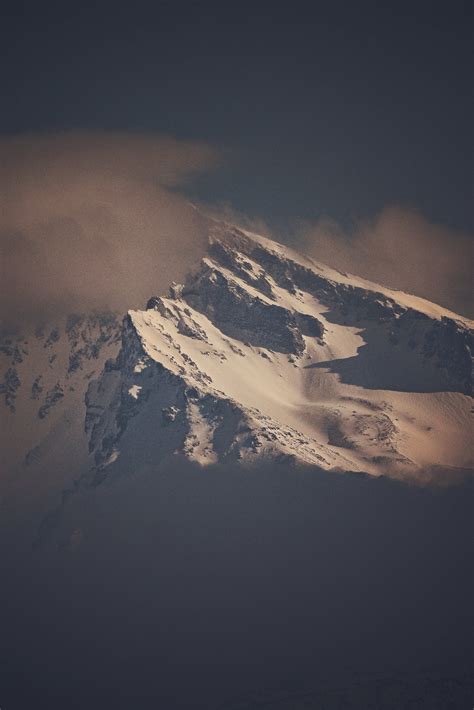 Snowy Mountain Peak Against Cloudy Sky · Free Stock Photo