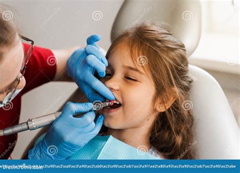 Child Dentist Makes Professional Teeth Cleaning In Dentistry