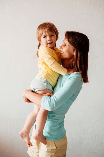 Ibu Muda Yang Bahagia Menggendong Putri Kecilnya Dinding Putih Untuk