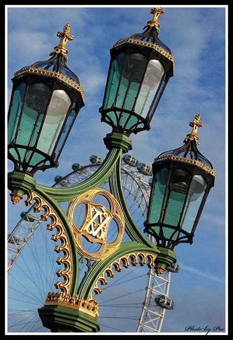 An Ornate Lamp Post With A Ferris Wheel In The Background And Blue Sky