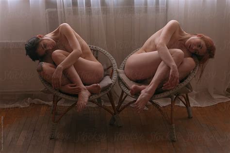 Two Naked Girls Artistically Sit On The Chairs In The Room