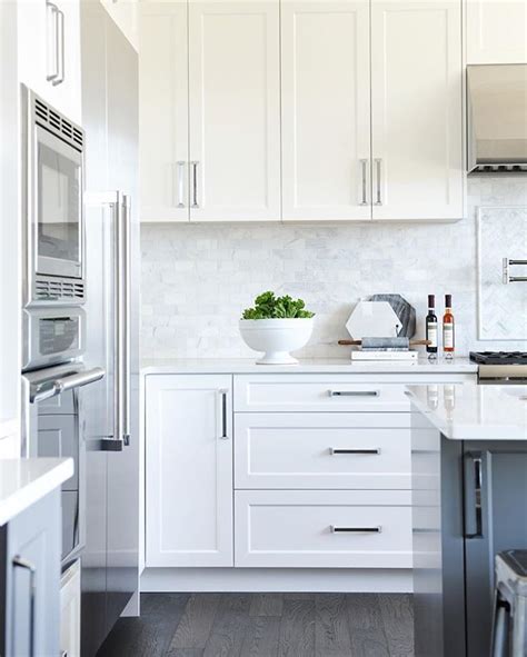 white shaker panel cabinets dark grey island marble backsplash white shaker kitchen