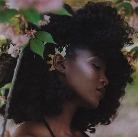 A Woman With Flowers In Her Hair Is Standing Under A Flowering Tree And Looking Off Into The