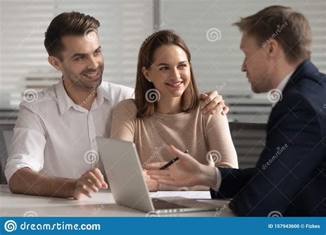Smiling Couple Consulting With Financial Advisor Or Real Estate Agent
