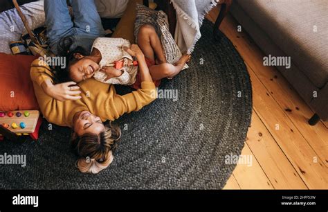 overhead view of a mother and her daughter laughing happily at home cheerful mother and
