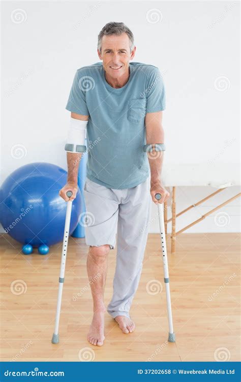 Smiling Mature Man With Crutches At Gym Hospital Stock Photo Image Of