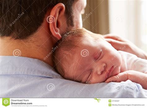 Father At Home With Sleeping Newborn Baby Daughter Stock