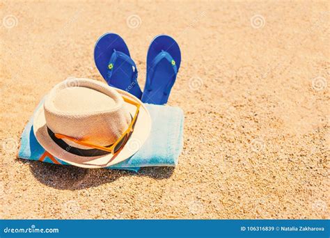 Blue Sandal Flip Flop Hat Sunglasses And Towel On Yellow San Stock