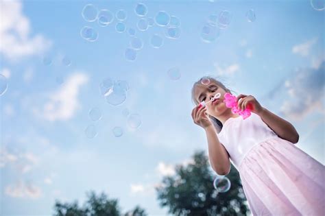 Premium Photo Girl Blowing Soap Bubbles In Park