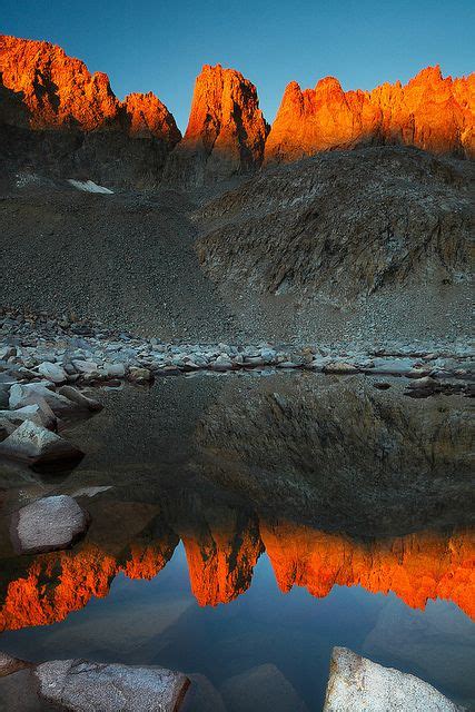 The Mountain Range Is Reflected In The Still Water At Sunset With