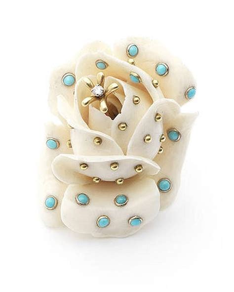 A White Flower With Blue And Gold Stones On It S Center In Front Of A