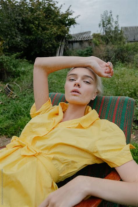 Portrait Of A Stylish Girl In A Yellow Retro Dress Which Lies In A